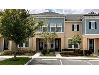 Inviting two-story townhome with neutral stucco and light blue siding, complemented by well-maintained landscaping at 1515 Carey Palm Cir, Kissimmee, FL 34747