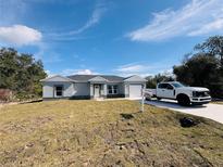 Newly constructed one-story home with a gray exterior and attached garage at 1317 Hillsborough Ct, Kissimmee, FL 34759