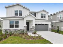 Two-story house with gray garage door and stone accents at 2918 Sharp Rd, Kissimmee, FL 34744