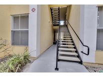 Exterior building shot of a stairwell to apartments with black handrails and painted stairs at 1100 Lake Shadow Cir # 2101, Maitland, FL 32751