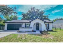 Charming single-story home featuring an arched entryway, manicured lawn, and attached two-car garage at 2220 Crystal Grove Ln, Lakeland, FL 33801