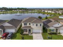 Two-story house with solar panels, lake view, and manicured lawn at 6718 Grace Hammock Rd, Harmony, FL 34773