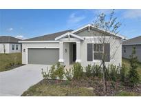 One-story house with gray siding, two-car garage, and landscaped front yard at 830 Ballantyne Dr, Lake Wales, FL 33898