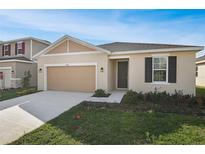 Inviting single-Gathering home featuring a neutral palette, two-car garage and manicured lawn at 926 Heirloom Dr, Haines City, FL 33844