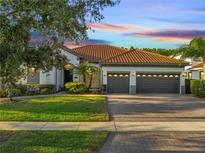 Beautiful single-story home with a tile roof, three-car garage, and well-manicured landscaping at 2891 Swoop Cir, Kissimmee, FL 34741