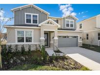 Two-story house with gray siding, stone accents, and a two-car garage at 883 Griffon Ave, Lake Alfred, FL 33850