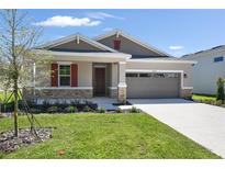 Beautiful single Gathering home with well-manicured lawn and neutral toned exterior with red shutters, stone accents and attached garage at 4220 Sawtooth Ct, Tavares, FL 32778