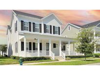 Charming two-story home featuring a welcoming front porch, black shutters, and lush landscaping at 1862 Beach Ridge Rd, Celebration, FL 34747