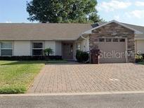 Charming single-story home with stone accents, brick driveway, and well-manicured lawn at 2724 Shelby Ruth Pl, Saint Cloud, FL 34769