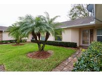 Well maintained front yard with green grass, brick walkway, decorative palm trees and trimmed bushes at 2724 Shelby Ruth Pl, Saint Cloud, FL 34769