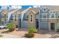 Attractive townhome with two-car garage, stone accents, and well manicured landscaping at 2106 Chatham Place Dr, Orlando, FL 32824