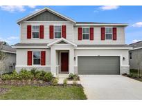 Charming two-story home with red shutters and manicured landscaping, showcasing curb appeal at 1647 Sugarbelle Cir, Mascotte, FL 34753