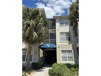 A condo building with a blue awning and palm trees in front of the building at 3301 Whitestone Cir # 308, Kissimmee, FL 34741
