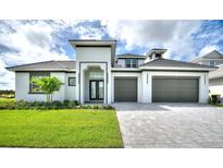 Beautiful two-story home featuring a well-manicured lawn, brick driveway, and a spacious two-car garage at 107 Hampton Loop, Davenport, FL 33837