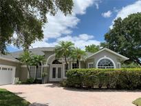 Charming home featuring a beautiful front yard, complemented by well-maintained landscaping and double door entrance at 14421 Hatchee Ct, Orlando, FL 32837