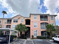 Exterior view of condo building with parking and landscaping at 13512 Turtle Marsh Loop # 736, Orlando, FL 32837