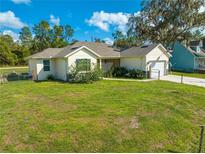 A charming single-story home with a well-maintained lawn and cozy curb appeal under a partly cloudy sky at 2909 Annalee Rd, Saint Cloud, FL 34771