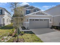 Two-story home with stone accents, a well-manicured lawn, and a two-car garage at 195 Bull Frog Ln, Umatilla, FL 32784