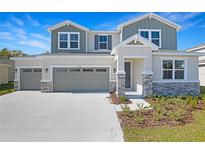 Charming two-story home featuring a three-car garage and stone accents at 1496 August Gray Dr, Kissimmee, FL 34744