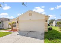 Charming one-story home featuring a two-car garage, landscaped yard, and neutral color palette at 1548 Tiverton Blvd, Winter Garden, FL 34787