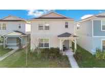 Charming two-story home with a covered front porch and well-maintained lawn at 1853 Summer Serenity Dr, Kissimmee, FL 34744