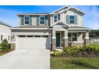 Charming two-story home featuring a two-car garage, stone accents, blue shutters and landscaped front yard at 535 Summit River Dr, Apopka, FL 32712
