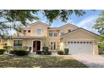 Charming two-story home featuring a well-manicured front yard, arched doorway, and a convenient two-car garage at 9040 Paolos Pl, Kissimmee, FL 34747