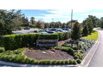 Bay Hill Club & Lodge entrance featuring manicured landscaping, stone signage, and ample parking at 6258 Masters Blvd # C204, Orlando, FL 32819