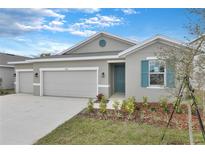 Beautiful single Gathering home with a two-car garage, fresh landscaping, and grey exterior paint at 2107 Riley Ave, Eagle Lake, FL 33839