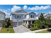 Charming two-story home with a paver driveway, an attached two-car garage, and a beautifully landscaped front yard at 11843 Imaginary Way, Orlando, FL 32832