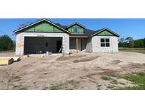 New construction home featuring concrete block walls and a two-car garage, presenting an unfinished canvas ready for customization at 3664 Cord Ave, St Cloud, FL 34772