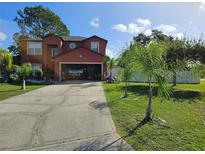 Charming two-story home with a spacious driveway, attached garage, and lush green lawn at 438 Spike Ct, Kissimmee, FL 34759