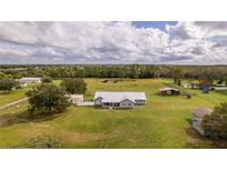 Expansive property featuring a charming home, lush greenery, and outbuildings, offering a serene countryside lifestyle at 4121 Albritton Rd, St Cloud, FL 34772