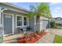 Inviting front porch with seating and a tropical palm tree at 4523 Ashtubula Ct, Orlando, FL 32818