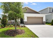 Charming single-Gathering home featuring a two-car garage and a well-manicured front lawn and stone facade at 1771 Carnelian St, Deland, FL 32720