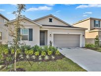 Charming single-story home with a two-car garage, manicured lawn, and inviting front door at 5422 Catmint Dr, Lake Hamilton, FL 33851