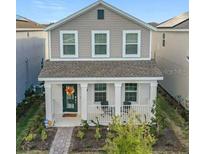 Two-story house with gray siding, a porch, and a landscaped front yard at 11720 Language Way, Orlando, FL 32832