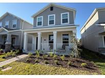 Charming two-story home featuring a welcoming front porch and well-manicured landscaping at 11720 Language Way, Orlando, FL 32832