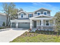 Charming two-story home boasts a three-car garage and inviting stone accents on a well-manicured front lawn at 3764 Deer Ridge Dr, Mount Dora, FL 32757