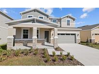 Charming two-story home featuring stone accents, a covered porch, and a well-maintained lawn at 1485 August Gray Dr, Kissimmee, FL 34744