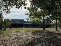 Exterior view of the two-story home with large yard and mature trees at 2728 Adair Rd, Davenport, FL 33837
