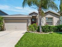 Charming single-story home featuring a two-car garage, manicured lawn and mature landscaping at 1569 Thetford Cir, Orlando, FL 32824