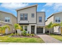 Contemporary two-story home with an attached garage, well manicured landscaping, and appealing curb appeal at 8932 Cabot Cliffs Dr, Davenport, FL 33896
