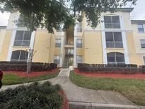 A low angle view shows the apartment building's exterior with balconies and manicured landscaping at 8910 Legacy Ct # 206, Kissimmee, FL 34747