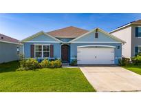 Charming blue single-Gathering home with a well-manicured lawn and a two-car garage at 1687 Park Side Ave, Kissimmee, FL 34744