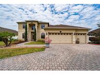 Beautiful two-story home featuring a three-car garage, landscaped yard, and a charming front entrance at 18035 Cadence St, Orlando, FL 32820