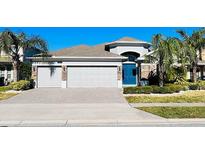 Three-car garage, brick accents, and a lush lawn enhance this home's curb appeal at 12276 Alder Branch Loop, Orlando, FL 32824