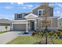 Beautiful two-story home with attached two car garage and manicured front lawn at 1698 Sugarbelle Cir, Mascotte, FL 34753