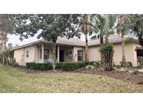 Tan house with covered porch and landscaped yard at 753 Largo Pass, Poinciana, FL 34759