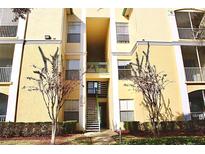 Exterior of tan colored building with outdoor staircase and pedestrian access to upper floors at 8830 Dunes Ct # 12 207, Kissimmee, FL 34747
